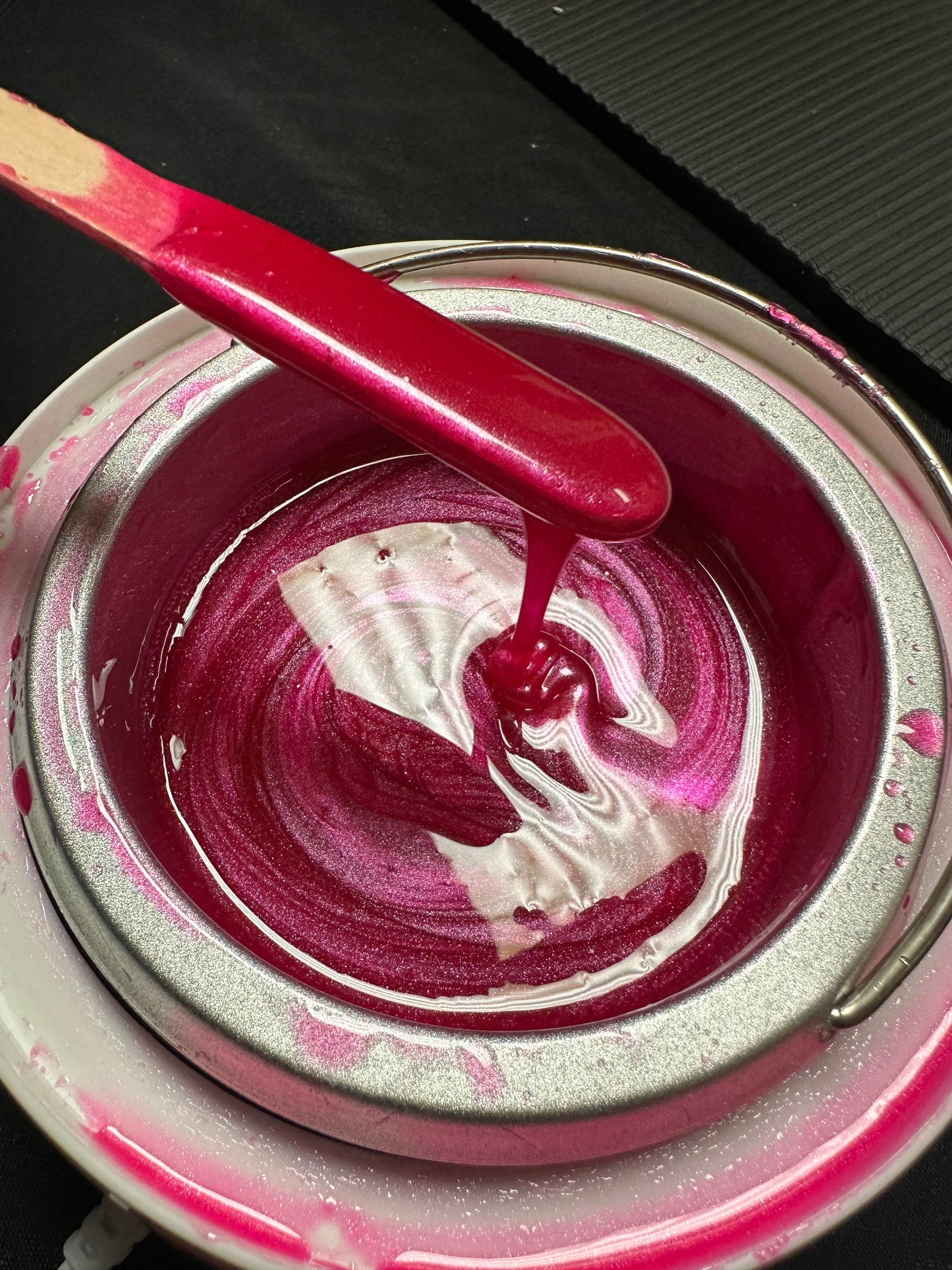 Melted Sexy Smooth Wax Tickled Pink hard wax in a professional wax warmer with wax applied to a wooden spatula.